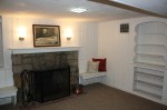 Finished basement area with fireplace and built-ins